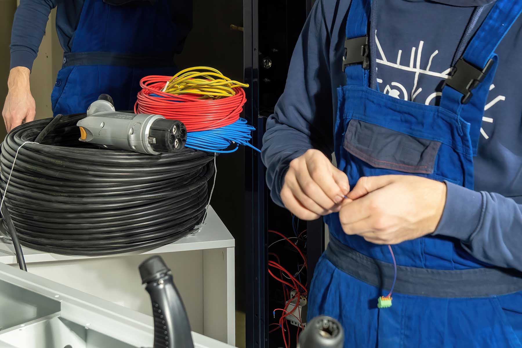 Technician works with cables for new charging plug