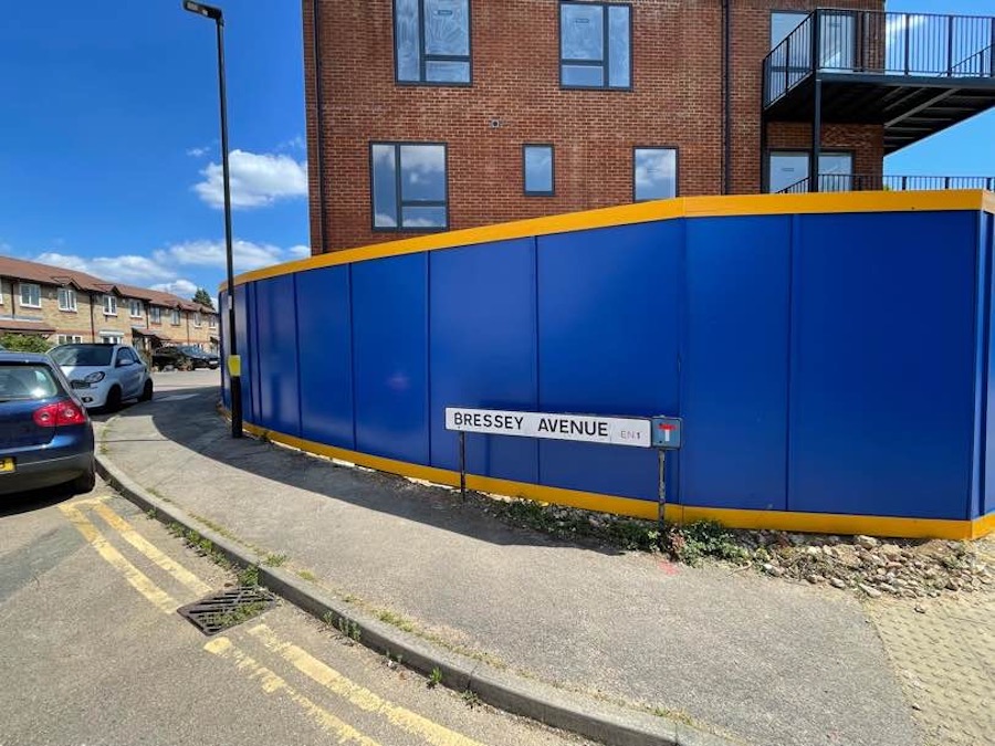 blue timber hoarding with yellow trim