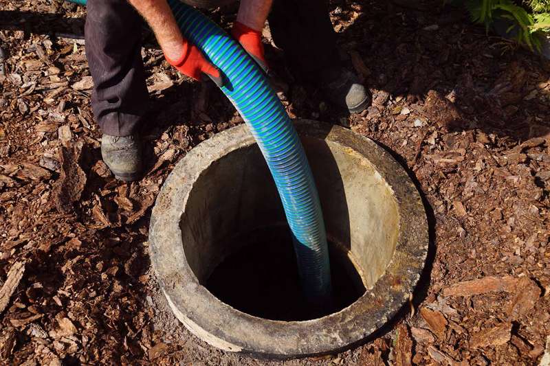 Pumping out sewage from a septic tank. Pipe in the drainage pit.